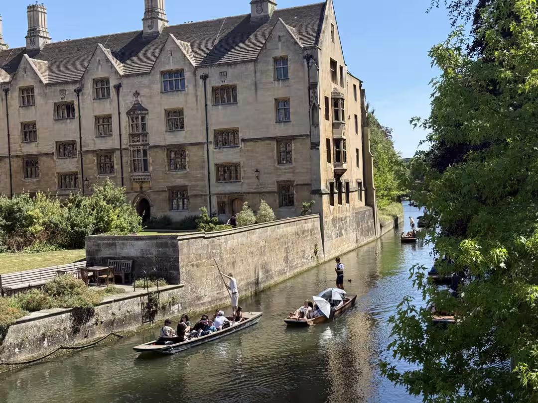 A Cambridge college beside the River Cam with a punt passing on the Backs